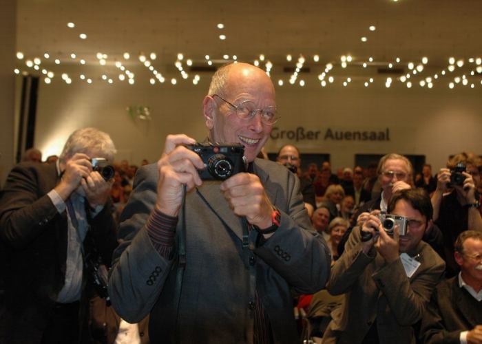 Will McBride mit der ihm verliehenen Leica auf der Preisverleihung 2004