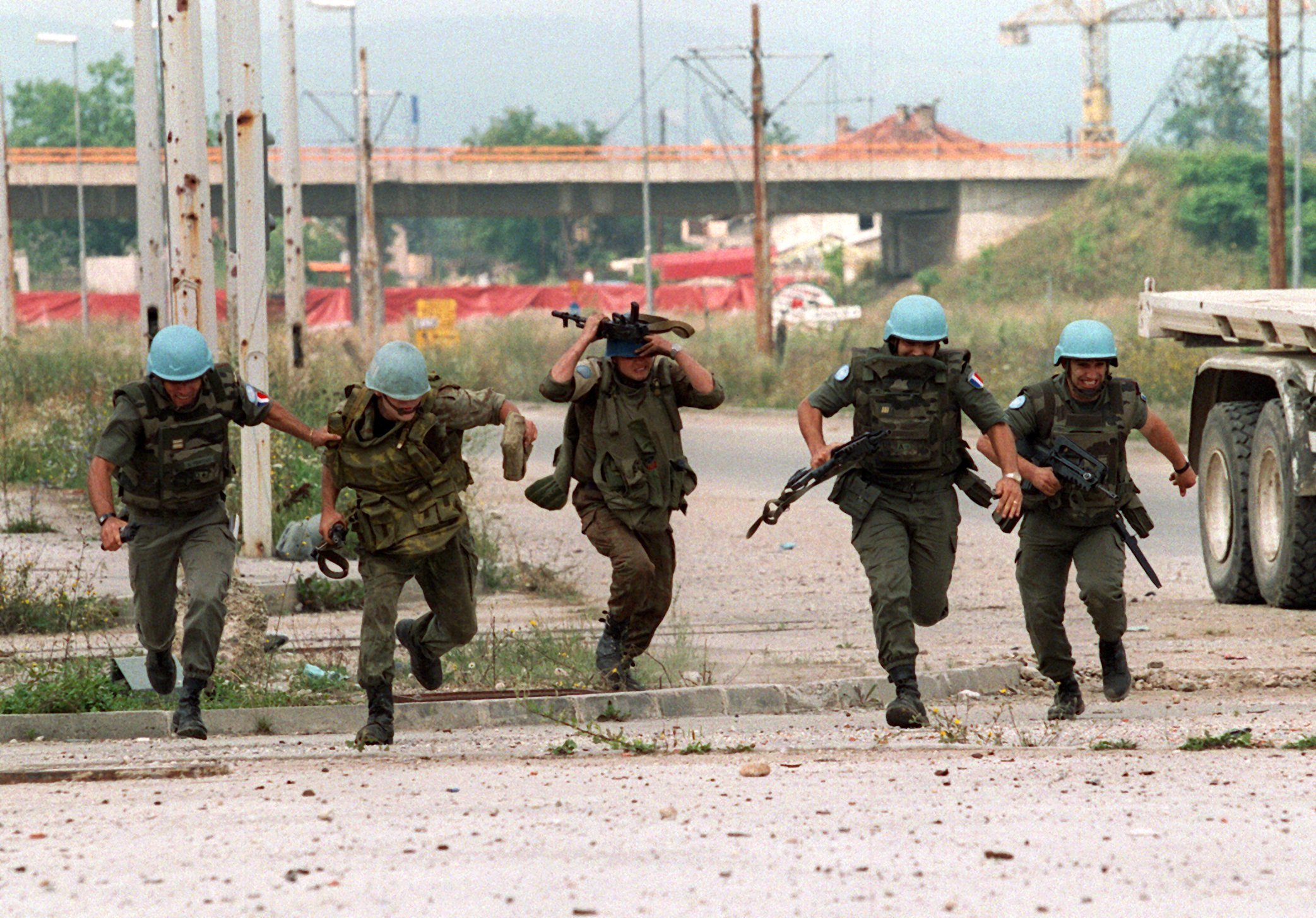 Anja Niedringhaus, UN-Soldaten unter Beschuss, Sarajevo, Bosnien, 20. Juli 1994. Französische und ukrainische UN-Soldaten flüchten, als serbische Scharfschützen das Feuer auf sie in der Innenstadt Sarajevos eröffnen. © Anja Niedringhaus/pa 