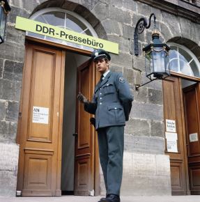 Blick auf den von einem hessischen Polizisten bewachten Eingang zum Pressebüro der DDR-Nachrichtenagentur ADN (Allgemeiner Deutscher Nachrichtendienst) während des zweiten innerdeutschen Gesprächs zwischen Bundeskanzler Brandt und DDR-Ministerpräsident Stoph in Kassel im Mai 1970 © picture-alliance / dpa | Alfred Hennig