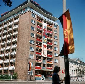 Mit Fahnen geschmückt sind Balkone an einem Wohnblock in Rostock. Die 17. Ostseewoche stand ganz im Zeichen des 25. Jahrestages der DDR, undatiert © picture-alliance / dpa | Günter Bratke